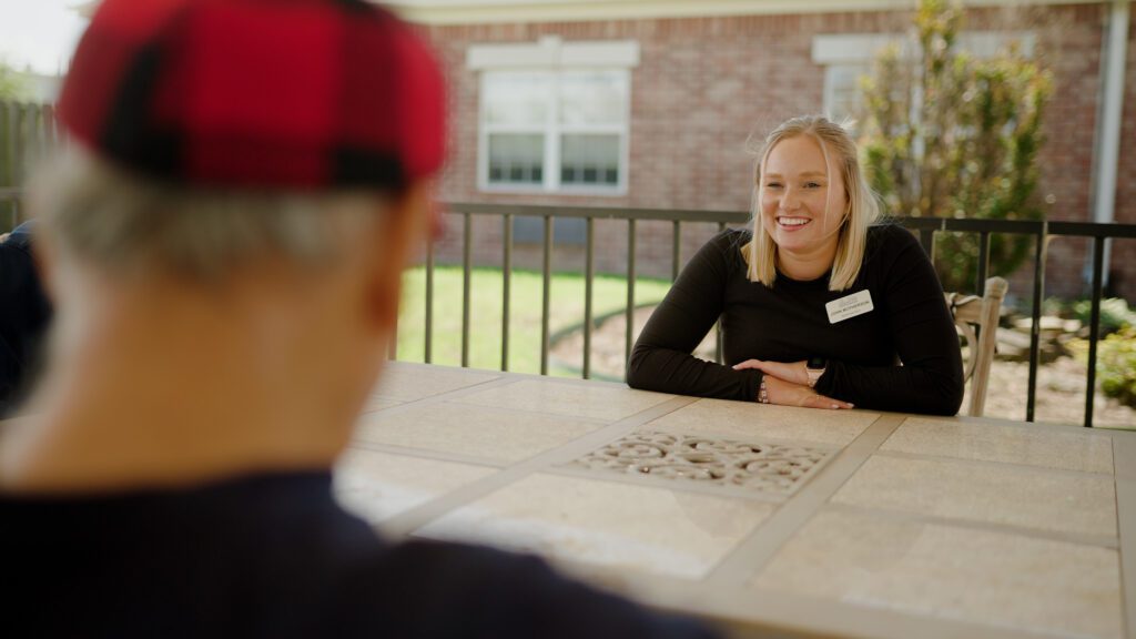 A nurse speaks to a man at a skilled nursing facility
